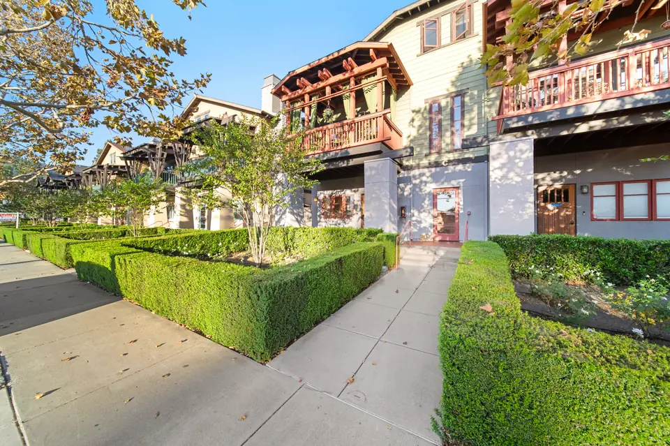 Front of the building with clipped hedges and a walkway to the entry