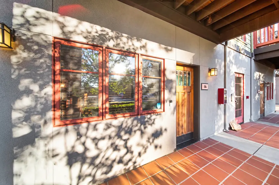Entry porch with red-trimmed windows and a tile floor
