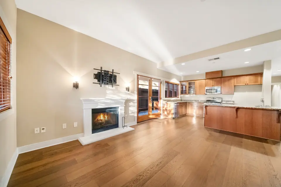 Living room fireplace with the kitchen behind it. Digitally added fire