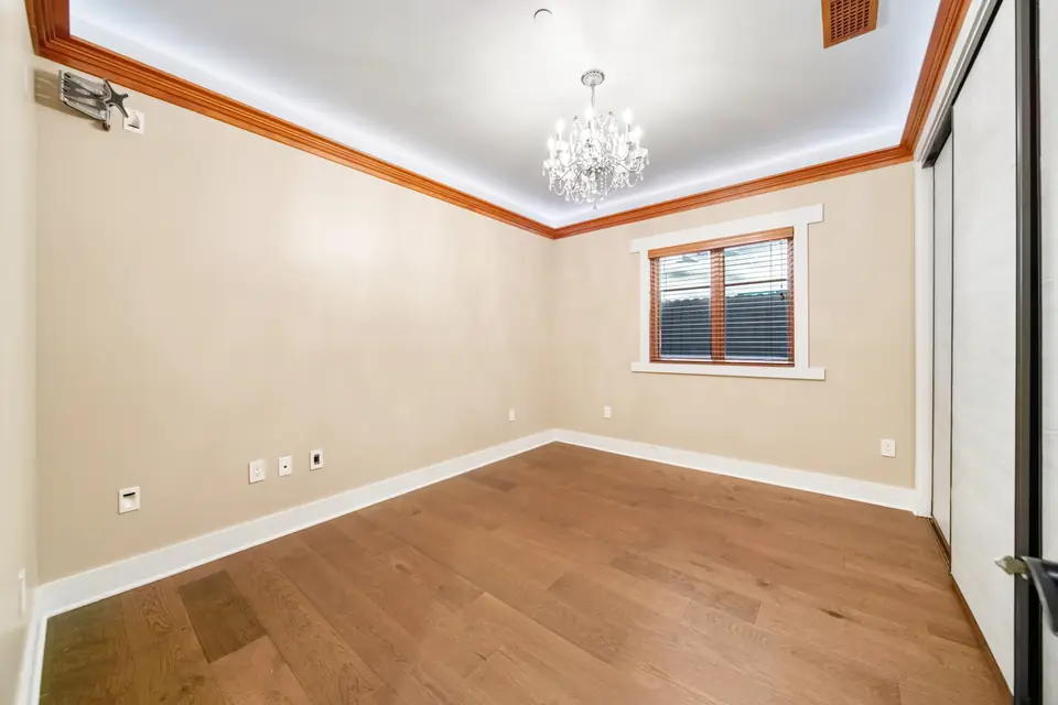 Bedroom with a chandelier and lit crown molding