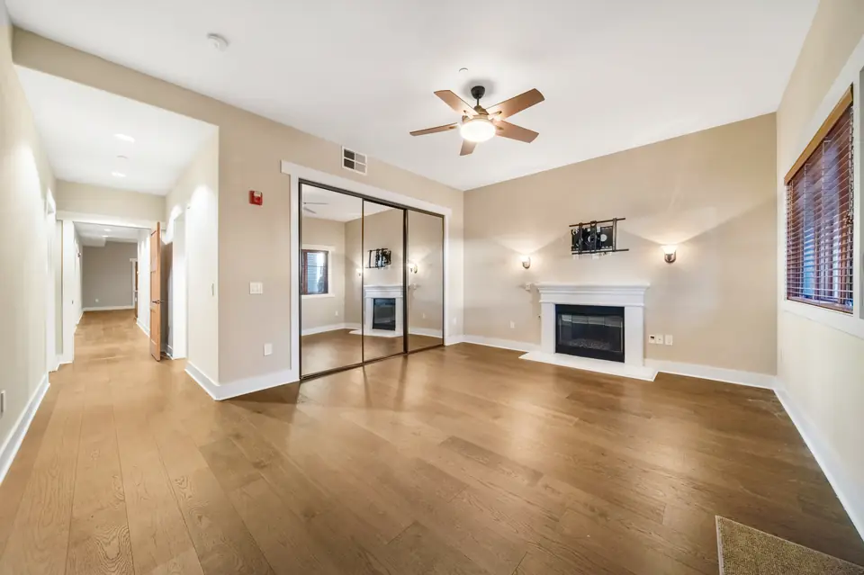 Bedroom with a ceiling fan, mirrored closet and fireplace