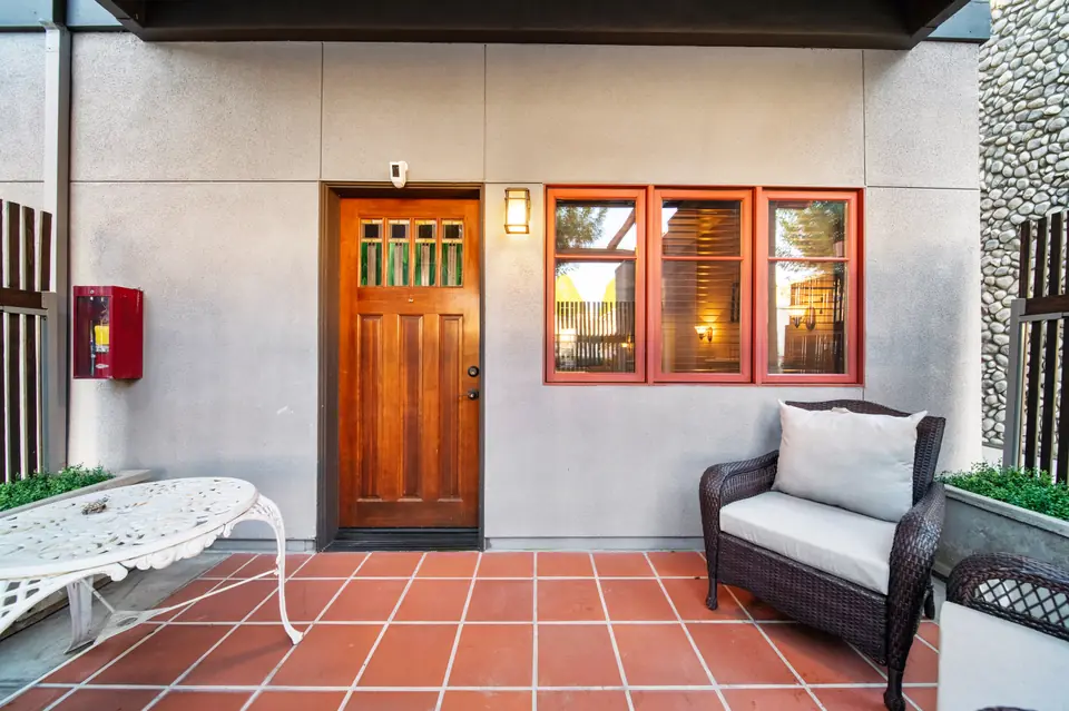 Patio with a wood door, seating and a tile floor