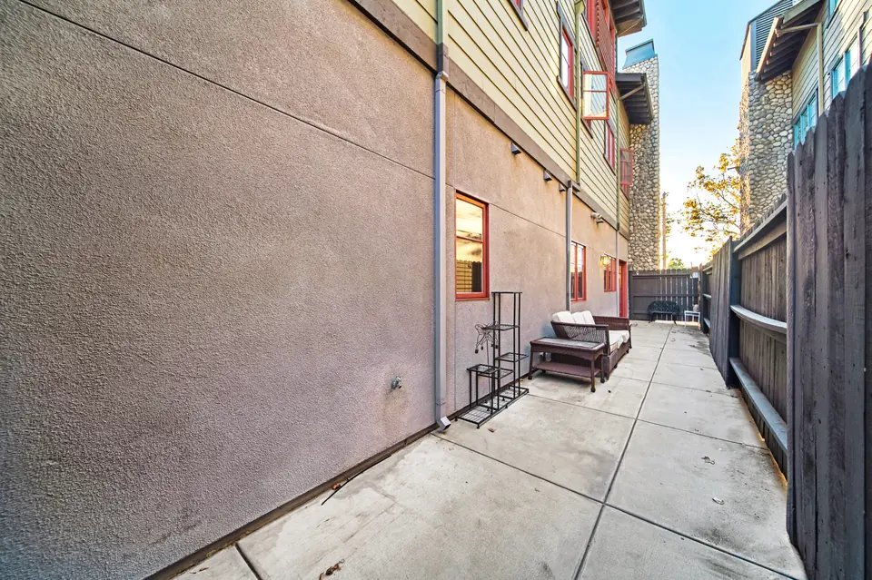 Rear patio along the stucco wall with a bench