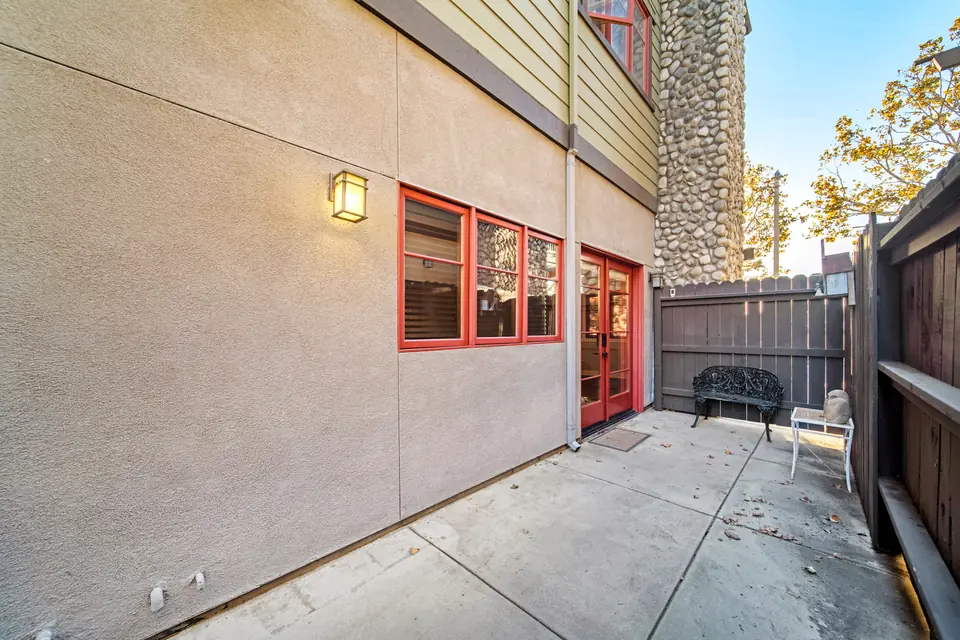 Rear patio with a wall light and a gate