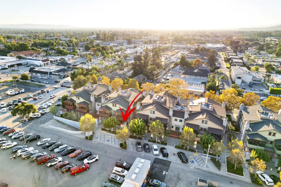 Aerial view at golden hour with an arrow marking the home